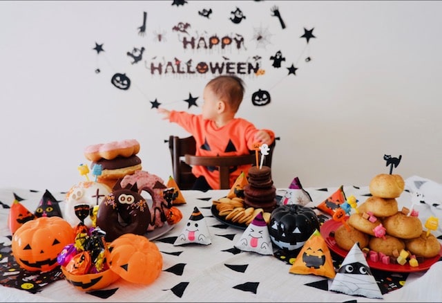 かぼちゃの置物やハロウィンのお菓子をテーブルに飾っている